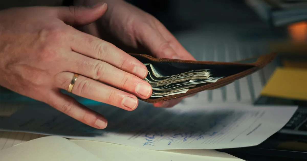 Trabalhador segurando carteira de trabalho e calculadora, simulando perda do seguro-desemprego