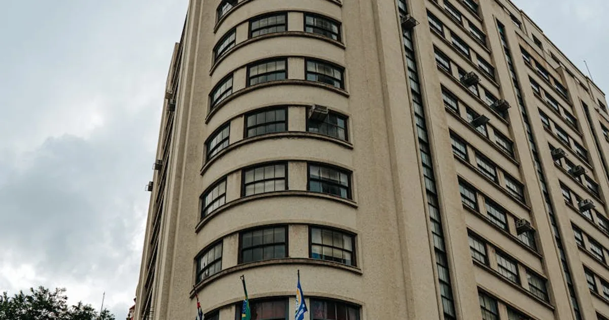 Empresário usando computador com painel da plataforma INSS Empresa ao lado de documentos trabalhistas