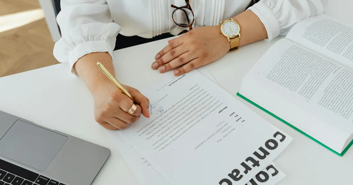 Documentos de rescisão de contrato de trabalho sobre uma mesa, com calculadora e caneta ao lado