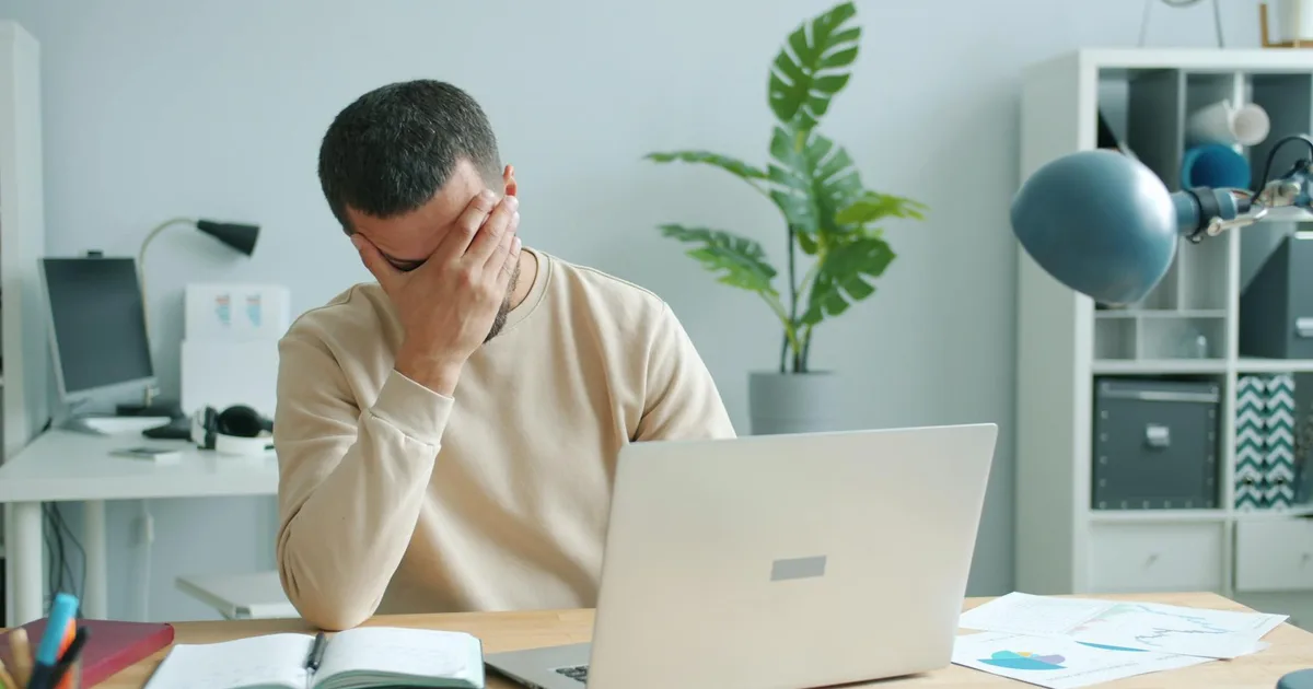 Trabalhador com dor no punho consultando advogado sobre demissão por tendinite
